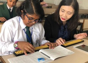 Our CEO Mrs. Tamai observing child practising Soroban