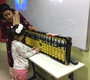 A student performing calculations on the soroban tool